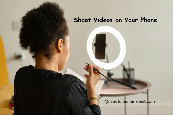 Woman recording video on phone with ring light setup for content creation.