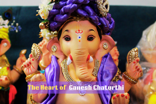 Colorful Lord Ganesha idol decorated with purple attire and flowers during Ganesh Chaturthi festival