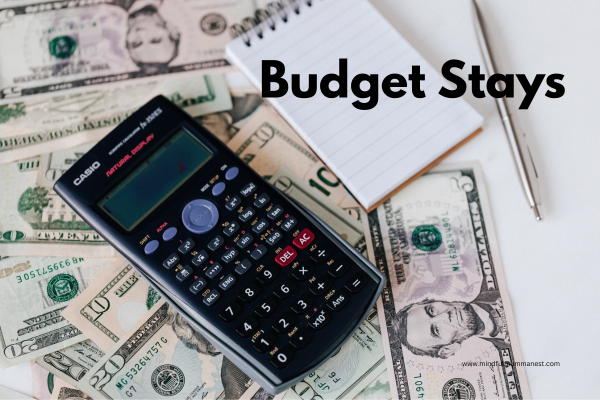 Calculator notebook and dollar bills used for planning budget-friendly travel stays
